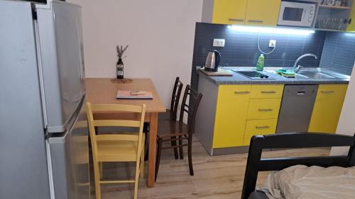 a small kitchen with a table and yellow cabinets at Lighthouse in Vodice
