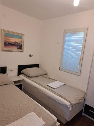 two beds in a small room with a window at Lighthouse in Vodice