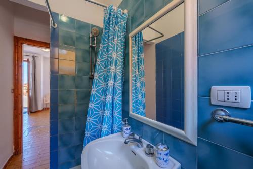 a blue bathroom with a sink and a mirror at La casa di Gio in Isola Rossa