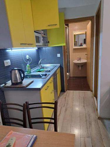 a kitchen with yellow cabinets and a sink and a table at Lighthouse in Vodice