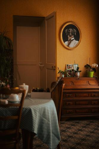 a dining room with a table and a picture on the wall at Le Lys Écossais in Aubigny-sur-Nère