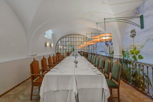 Un comedor largo con una mesa larga y sillas. en CoolRooms Palacio Villapanés 5 GL, en Sevilla