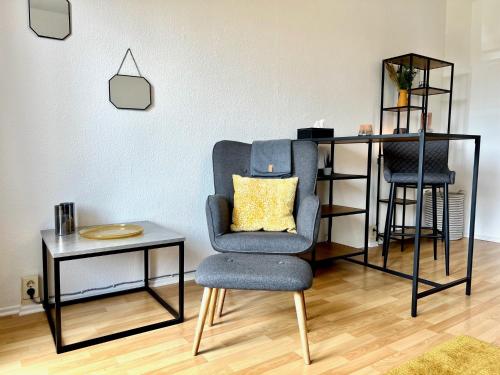 a living room with a chair and a table at Business Appartements Arnstadt OT Marlishausen in Arnstadt