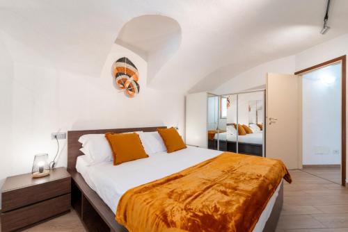 Tremezzina Charming Apartment by Wonderful Italy في تريميزو: غرفة نوم بسرير كبير ومرآة