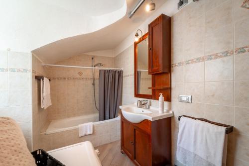 Tremezzina Charming Apartment by Wonderful Italy في تريميزو: حمام مع حوض ومرحاض وحوض استحمام