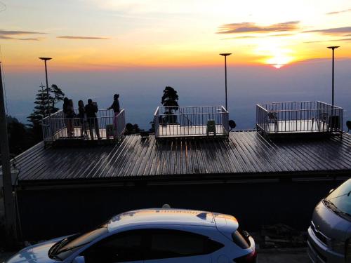 a group of people standing on top of a roof at สเตชั่นภูทับเบิก-บ้านดาดฟ้าทะเลหมอก in Ban Tha Kok Hai