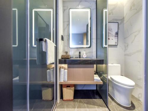 a bathroom with a toilet and a sink and a mirror at GreenTree Eastern Hotel Xuzhou Pei County Binhe Road in Pei