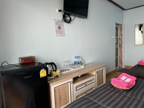 a kitchen with a black refrigerator and a counter at สเตชั่นภูทับเบิก-บ้านดาดฟ้าทะเลหมอก in Ban Tha Kok Hai