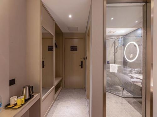 uma casa de banho com uma cabina de duche ao nível do chão e uma porta de vidro em Gya Hotel Suzhou Hanshan Temple Binhe Road em Suzhou