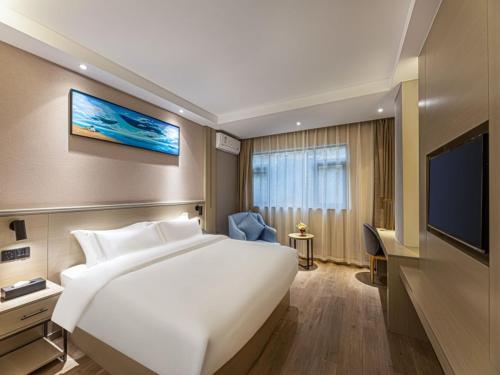 Gya Hotel Suzhou Hanshan Temple Binhe Road في سوتشو: غرفة فندقية بسرير كبير وتلفزيون بشاشة مسطحة