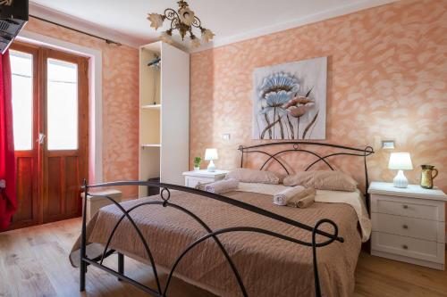 a bedroom with a bed in a room with orange wallpaper at Relax House and Fitness 8 in Villanova Monteleone