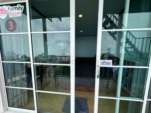 an open glass door with a view of a balcony at สเตชั่นภูทับเบิก-บ้านดาดฟ้าทะเลหมอก in Ban Tha Kok Hai