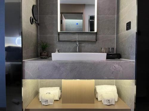 a bathroom with a sink and a mirror at GreenTree Eastern Hotel Yiwu International Trade City in Yiwu