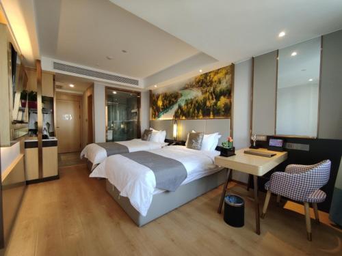 um quarto de hotel com uma cama grande e uma secretária em GreenTree Eastern Hotel Xinjiang Urumqi Renmin Road em Ürümqi