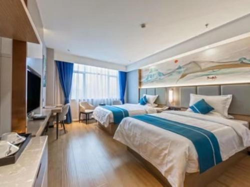 Cette chambre comprend deux lits et une télévision. dans l'établissement GreenTree Eastern Hotel Duyun Wen'an Jinmei Times Bus Station, à Yinzhan