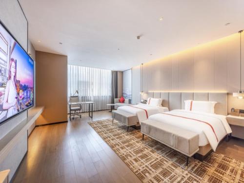 a hotel room with two beds and a flat screen tv at GreenTree Eastern Hotel Lanzhou Zhongchuan Airport Eastern Airlines Center in Lanzhou