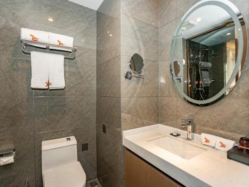 uma casa de banho com um WC, um lavatório e um espelho. em GreenTree Eastern Hotel Huai'an Suning Plaza West Huaihai Road em Huai'an