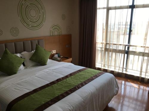 a bedroom with a large bed and a large window at GreenTree Inn Suqian Yanghe Xuhuai Road in Suqian