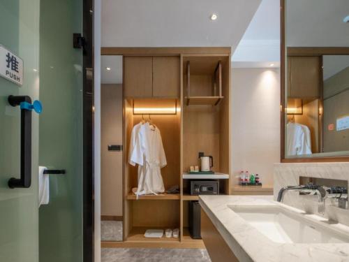a bathroom with a sink and a mirror at GreenTree Eastern Hotel Tianjin Wuqing Wanda Plaza in Wuqing