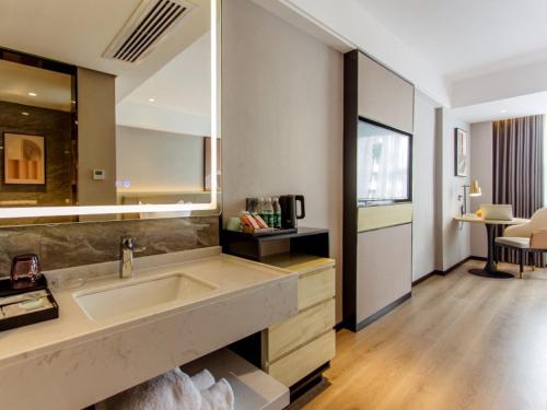 a bathroom with a sink and a large mirror at VX Hotel Nanning Chaoyang Plaza Nanhu Park in Nanning