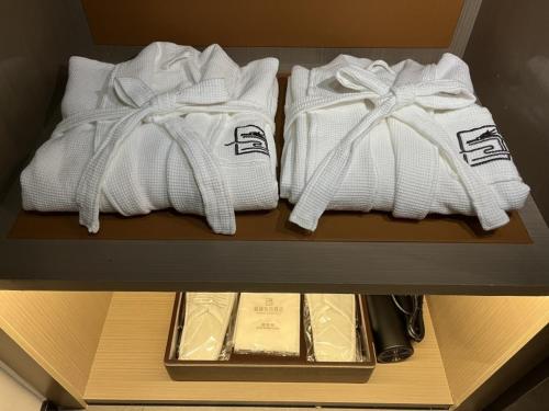 a shelf with three white towels in a drawer at GreenTree Eastern Hotel Yiwu International Trade City in Yiwu
