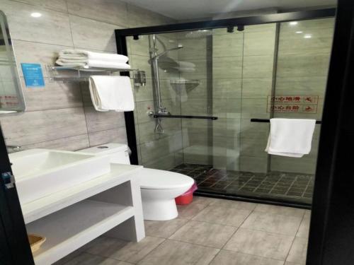 a bathroom with a shower and a toilet and a sink at Geli Hotel Hefei Modian University Mengxi Town in Hefei