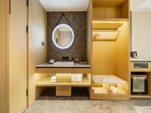 a bathroom with a sink and a mirror at GreenTree Eastern Hotel Nanjing Jiangning University in Jiangning