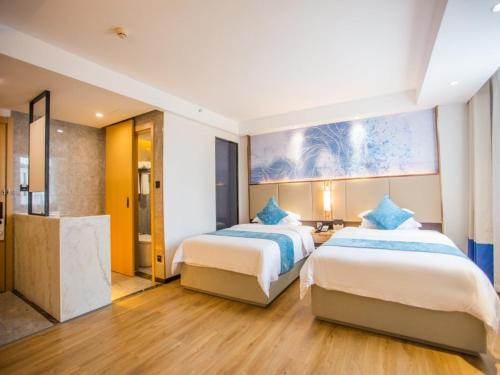 a hotel room with two beds and a bathroom at GreenTree Eastern Hotel Huai'an Suning Plaza West Huaihai Road in Huai'an