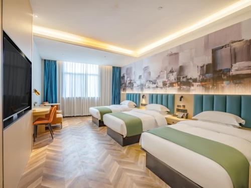 een hotelkamer met 4 bedden en een flatscreen-tv bij GreenTree Inn Express Hotel Changzhou Wujin Economic Development Zone Qishuyan Yaoguan in Changzhou