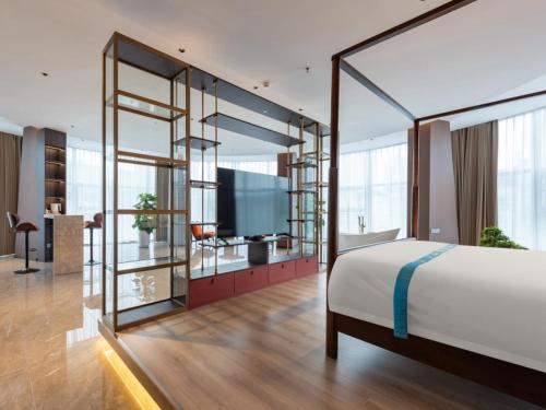 a bedroom with a large white bed and a tv at VX Hotel Xuzhou Suining Remin Road in Suining