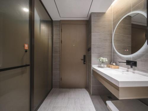 a bathroom with a sink and a mirror at GreenTree Eastern Hotel Dezhou Qingyun Yingcai Road Financial Building in Dezhou