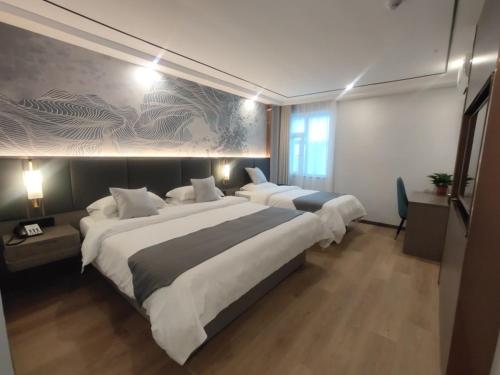 a large bedroom with two beds and a wall mural at GreenTree Eastern Hotel Huai'an University in Huai'an