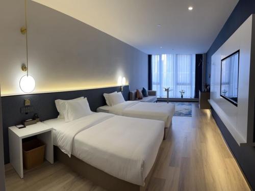 a hotel room with two beds and a living room at GreenTree Eastern Hotel Yiwu International Trade City in Yiwu