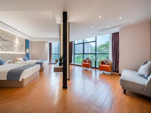 Habitación de hotel con cama y sala de estar. en GreenTree Inn Yulin Hongjin Markey Yide, en Yulin