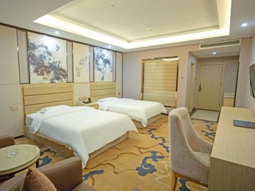 YichunにあるVX Hotel Yichun Yuanzhou Government High-Speed Railwayのベッド2台、テーブルと椅子が備わるホテルルームです。