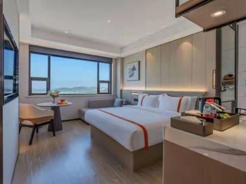 een hotelkamer met een groot bed en een tafel bij GreenTree Eastern Hotel Wuhan Optics Valley East Lake Wuhan University in Wuhan