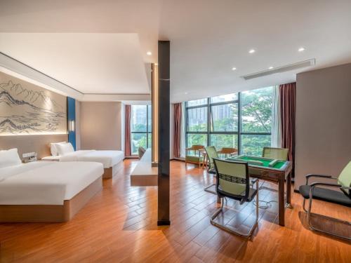 a hotel room with a bed and a table in it at Geli Hotel Suqian Shuyang Yingbin Avenue in Shuyang