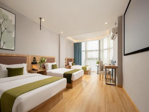 a hotel room with two beds and a table and chairs at GreenTree Inn Express Hotel North Huaihai Road in Huai'an