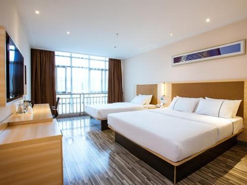 a hotel room with two beds and a television at GreenTree Alliance Jiangsu Huai'an Suning Plaza in Huai'an