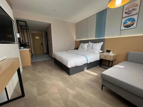 pokój hotelowy z łóżkiem i kanapą w obiekcie VX Hotel Anhui Suzhou Dangshan Zhongyuan Road w mieście Dangshan
