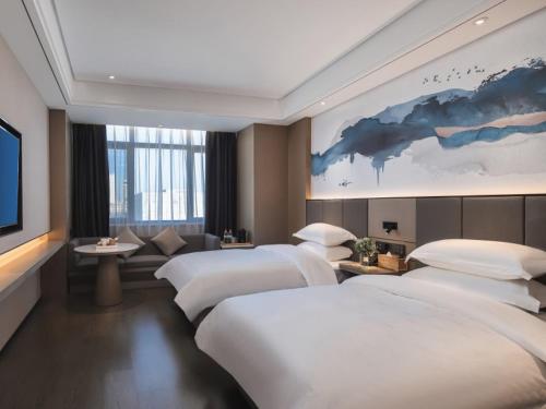 um quarto de hotel com duas camas e uma televisão de ecrã plano em GreenTree Eastern Hotel Chuzhou Suchu Industrial Park em Chuzhou