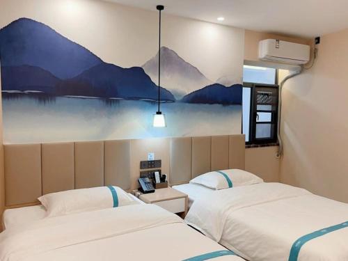 two beds in a room with a painting on the wall at VX Hotel Tianjin West Yongyang Road Florentia Town in Wuqing