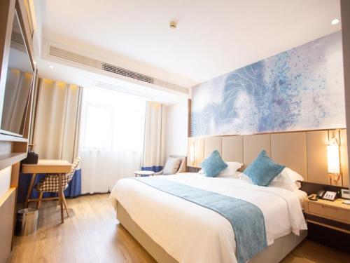a hotel room with a large bed and a desk at GreenTree Eastern Hotel Huai'an Suning Plaza West Huaihai Road in Huai'an