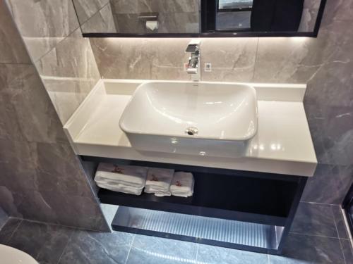 a bathroom with a sink and a mirror and towels at GreenTree Eastern Hotel Ji'an City Suichuan Industrial Park in Suichuan