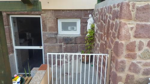 a stone wall with a gate and a window at Agapé Mini Stúdió in Balatonalmádi