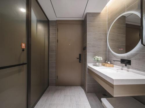 a bathroom with a sink and a mirror at GreenTree Eastern Hotel Chuzhou Suchu Industrial Park in Chuzhou