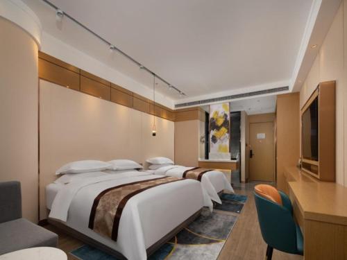 a row of beds in a hotel room at GreenTree Eastern Hotel Tianjin Wuqing Wanda Plaza in Wuqing
