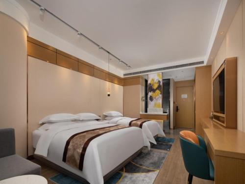 fila de camas en una habitación de hotel en GreenTree Eastern Hotel Tianjin Wuqing Wanda Plaza, en Wuqing