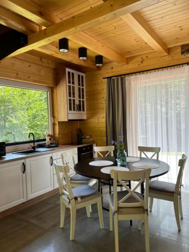 - une cuisine avec une table, des chaises et un évier dans l'établissement Drewniany Domek nad Doliną Dunajca, à Zakliczyn