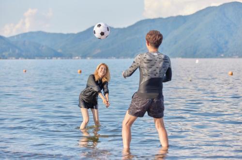 two people playing with a soccer ball in the water at Resoreat Takashima in Imazu